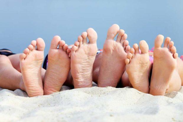 Bare feet outdoors on sandy beach.